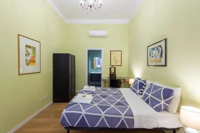 a bedroom with a purple bed and a chandelier at Luxury Three Bedrooms flat in Roma Center in Rome