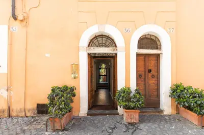 two arched doors on a building with potted plants at iFlat Loft&Pool in Trastevere in Rome