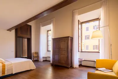 a bedroom with a bed and a window at Palazzo Berardi: Renaissance Downtown Luxury Villa in Rome