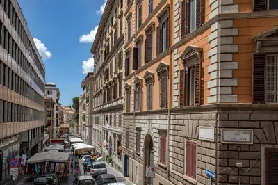 a city street with parked cars and buildings at Daplace - Hotel Gran Torino Suites in Rome