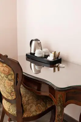 a table with a tea kettle and a chair at Stevenson Rooms in Rome