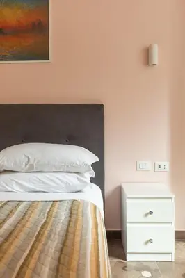 a bedroom with a bed and a white night stand at Stevenson Rooms in Rome