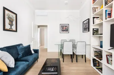 a living room with a blue couch and a table at Idyllia - Elegant central flat in Rome