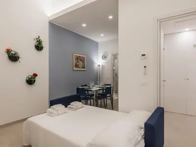 a bedroom with a white bed and a table at The Best Rent - Two-bedroom apartment close to San Pietro in Rome