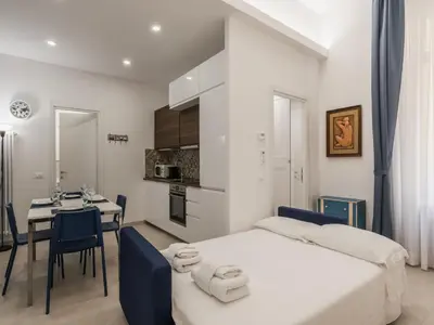 a bedroom with a bed and a table and a kitchen at The Best Rent - Two-bedroom apartment close to San Pietro in Rome