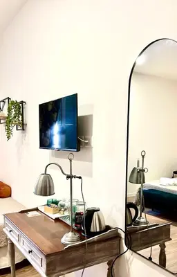 a living room with a table and a mirror at Termini Suite Inn Rome in Rome