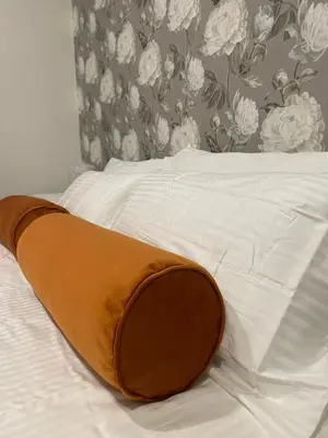 a white bed with a brown pillow on it at Termini Suite Inn Rome in Rome
