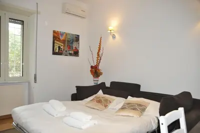 a bed with white sheets and pillows in a room at Mary's House in Rome