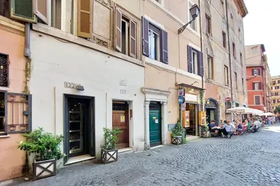a cobblestone street with a group of people sitting at tables at suity I cozy coronari apartment in Rome
