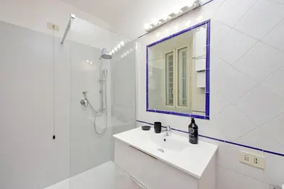 a white bathroom with a sink and a mirror at suity I cozy coronari apartment in Rome