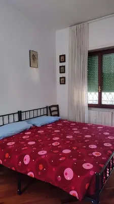 a bedroom with a bed with a red blanket with pink polka dots at Montagnola House in Rome