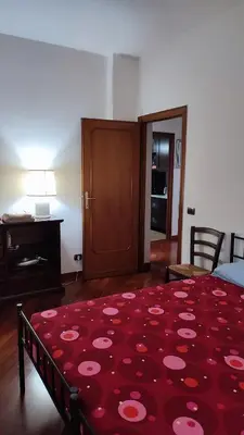 a bedroom with a red rug with pink flowers on it at Montagnola House in Rome
