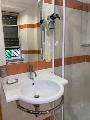 a bathroom with a white sink and a shower at Residenza in Rome