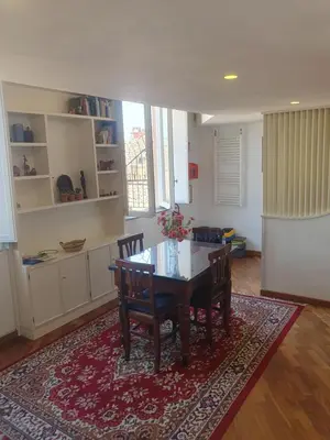 a dining room with a table and chairs on a rug at coronari apartments 2 in Rome