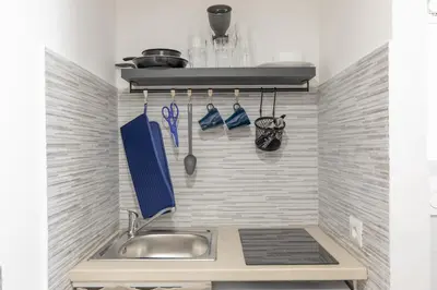 a kitchen with a sink and utensils on the wall at GuestHost - Comfy Studio x2 - Trastevere District! in Rome