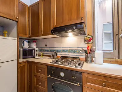 a kitchen with wooden cabinets and a stove top oven at Apartment Navona by Interhome in Rome