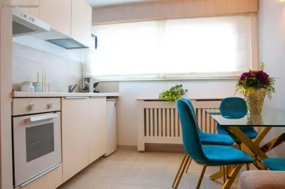 a kitchen with a table and blue chairs at Algima Flat Roma Ponte Milvio in Rome