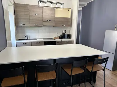 a kitchen with a large white counter and chairs at Roma Chic Flats Policlinico Gemelli in Rome