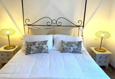 a white bed with two lamps on two tables at Aenea's B&B in Rome