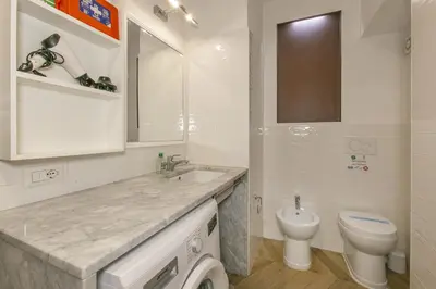 a white bathroom with a sink and a toilet at Trevi Little Palace #3 in Rome