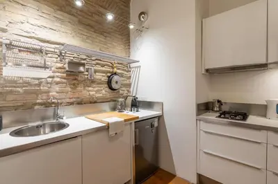a kitchen with a sink and a brick wall at Trastevere Lovely Apartment in Rome
