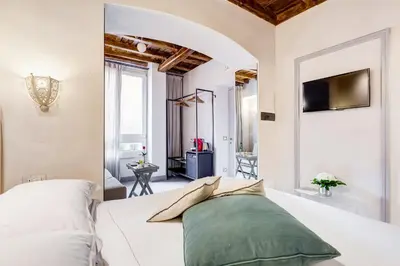 a bedroom with a white bed and a tv at Rome Frattina27 in Rome