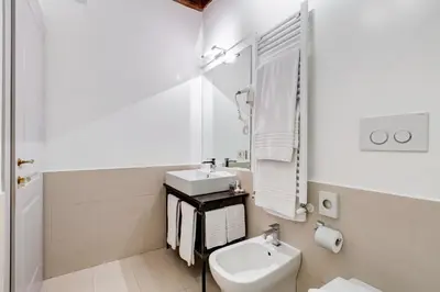 a white bathroom with a sink and a toilet at Rome Frattina27 in Rome