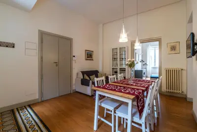 a dining room with a table and chairs and a living room at GuestHost - Bright & Roomy Apartment x6 - Trastevere District in Rome