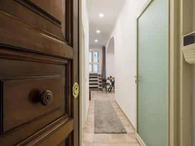 a hallway with a wooden door and a hallway with a table at The Best Rent - Gorgeous one-bedroom apartment near Piazza di Spagna in Rome