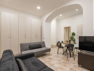 a living room with a couch and a tv and a table at The Best Rent - Gorgeous one-bedroom apartment near Piazza di Spagna in Rome