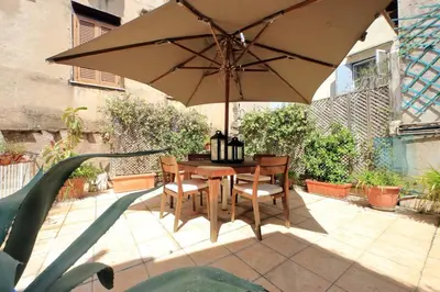 a table and chairs with an umbrella on a patio at Ottavia Terrace in Rome