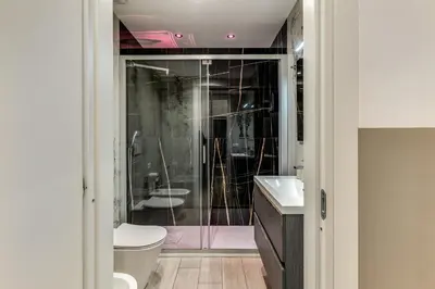 a bathroom with a shower and a toilet and a sink at A Touch of Rome Guesthouse in Rome