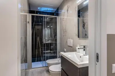 a bathroom with a shower and a toilet and a sink at A Touch of Rome Guesthouse in Rome