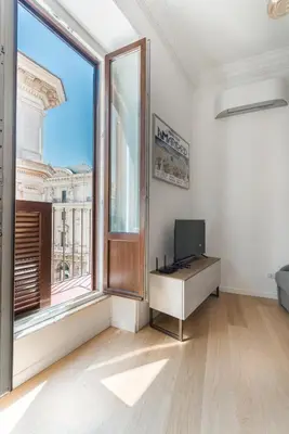 a white room with a television and a large window at Boutique Apartment 29 in Rome