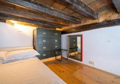 a bedroom with a bed and a dresser and a mirror at [Trastevere - Rome] Strategic and Comfortable Loft in Rome
