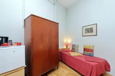 a small bedroom with a bed and a wooden cabinet at Cassiodoro19 in Rome