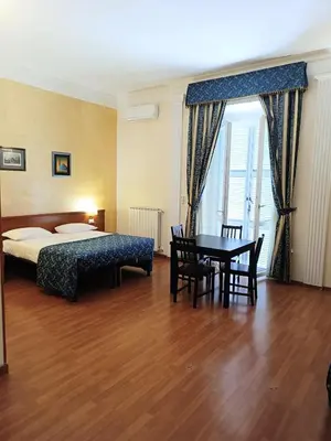 a hotel room with a bed and a table and chairs at Opera Italian Suite in Rome