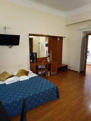 a bedroom with a bed and a desk and a mirror at Opera Italian Suite in Rome