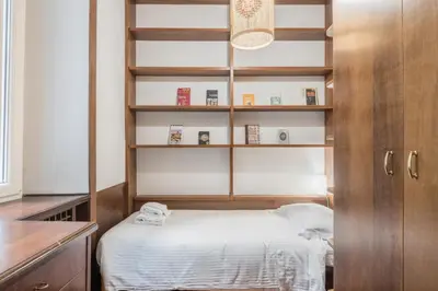 a small room with a bed and shelves at The Best Rent - Three-Bedroom apartment near Villa Borghese in Rome