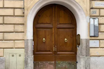 a wooden door in a building with an arch at The Best Rent - Three-Bedroom apartment near Villa Borghese in Rome