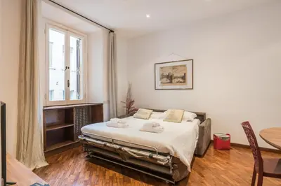a bedroom with a bed and a table and a window at The Best Rent - Three-Bedroom apartment near Villa Borghese in Rome