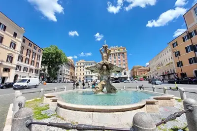 a fountain in the middle of a city street at Suite Barberini in Rome