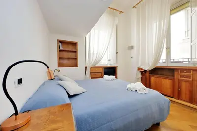 a bedroom with a blue bed with two towels on it at Suite Barberini in Rome