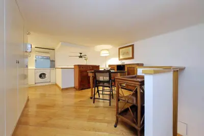 a living room with a table and a kitchen at Suite Barberini in Rome