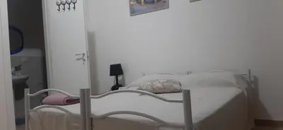 a white bed in a room with a door at CorneliaGuestHouse in Rome