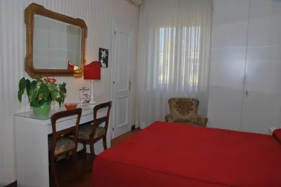 a bedroom with a red bed and a mirror at Attico Monteverde in Rome