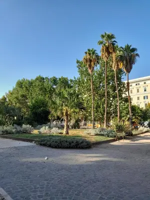 a park with palm trees and a building in the background at Pensiero Romano in Rome