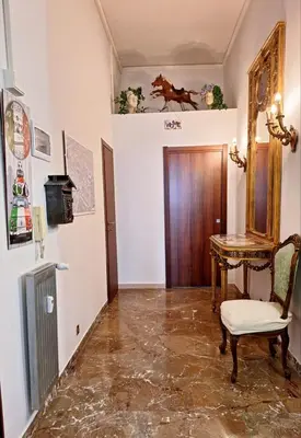 a hallway with a chair and a table and a door at Pensiero Romano in Rome