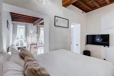 a white bedroom with a bed and a tv at Barberini Exclusive Loft in Rome