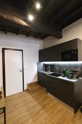 a kitchen with black cabinets and a white door at Casa Orchidea in Rome